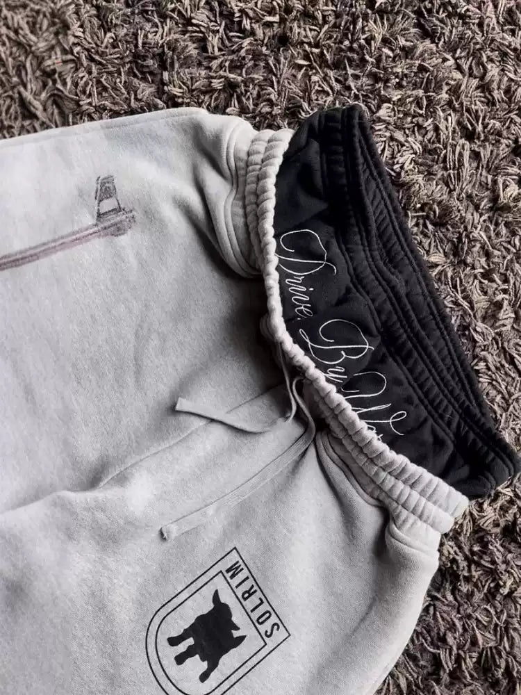 Two pairs of pants with brand logos on a textured surface