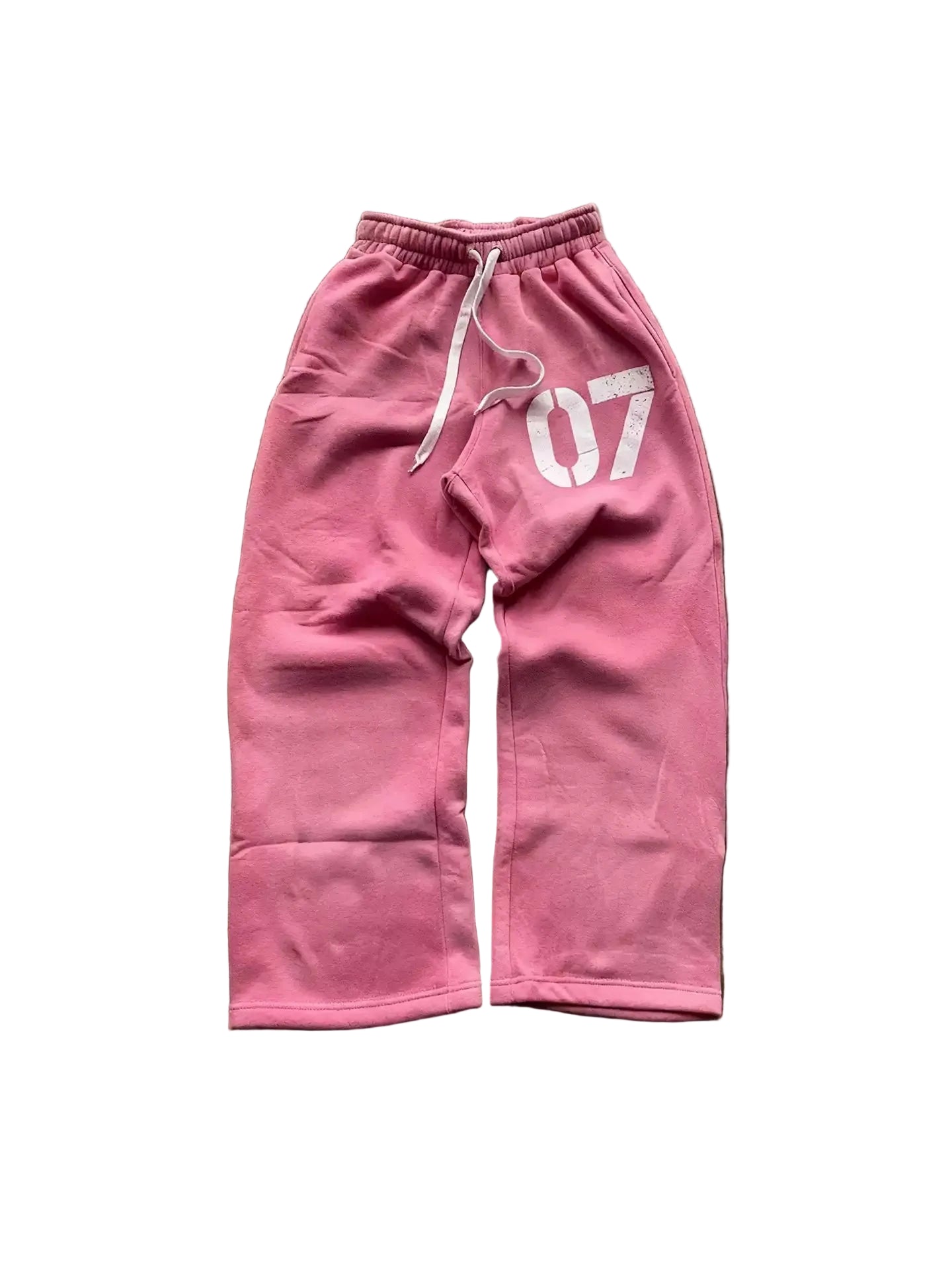 Pink sweatpants with '07' printed on a brown surface