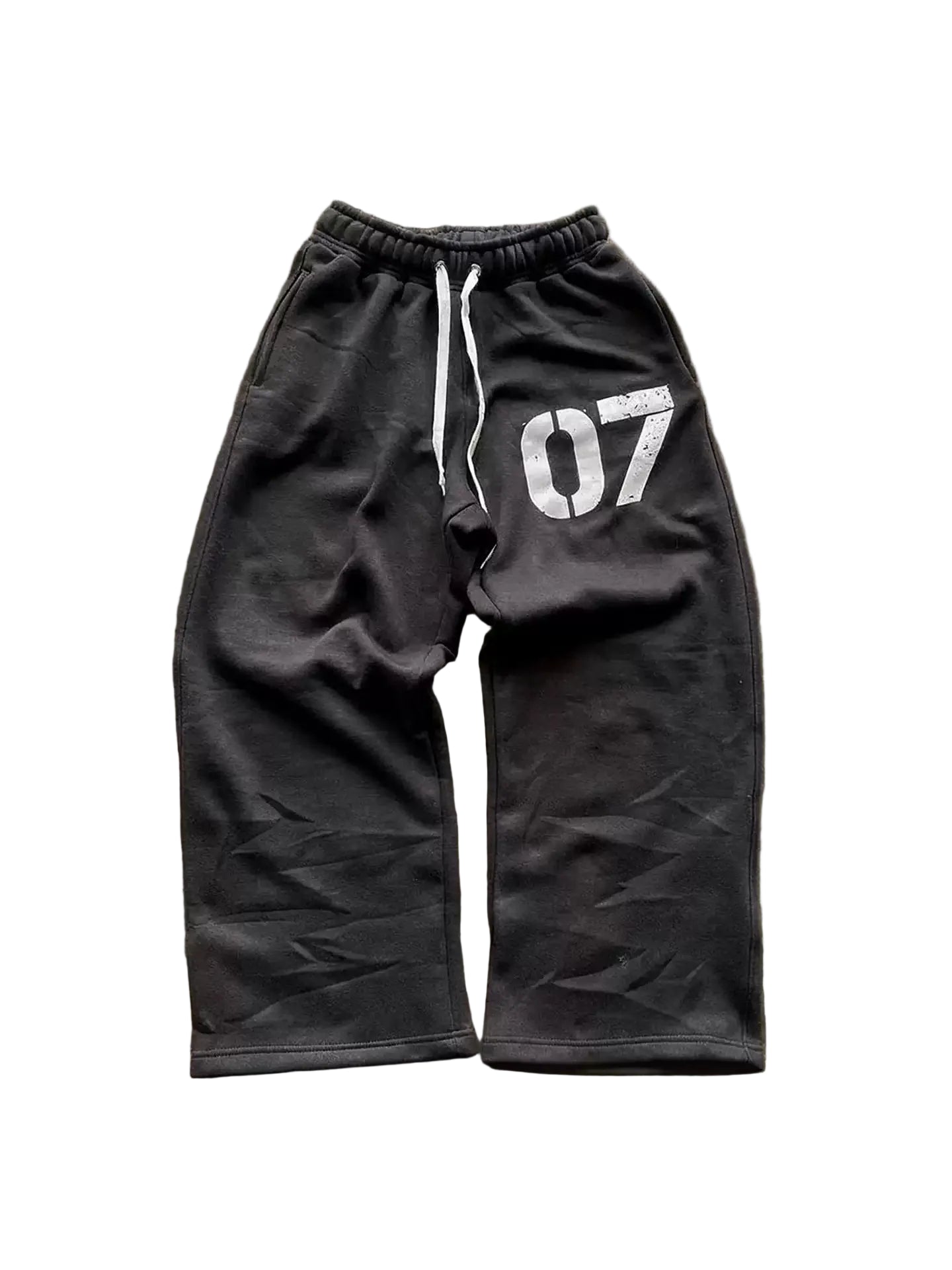 Black sweatpants with '07' printed on a textured brown background