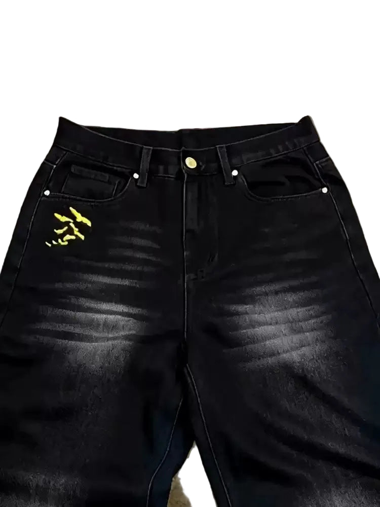 Black jeans with yellow logo on a textured surface