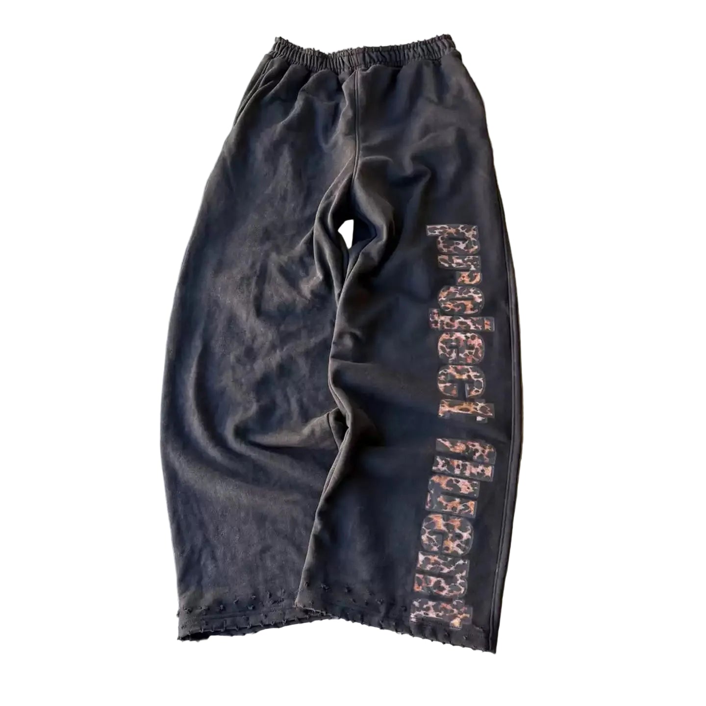 Black pants with a patterned side strip on a gray concrete surface